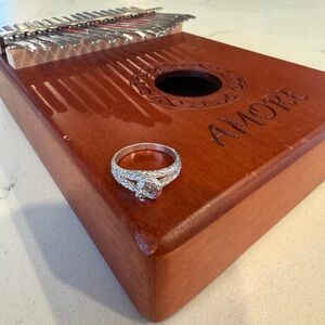 Silver Diamond-Style Solitaire Ring on Wooden Kalimba